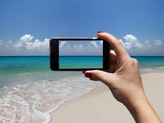 woman photographing a beach with i-phone