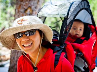 A woman hikes while carrying her 6 month old in a baby hiking backpack.