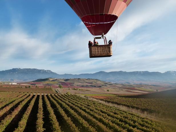 A hot air balloon drifts over the vineyards in Rioja, Spain A hot air balloon drifts over the vineyards in Rioja, Spain