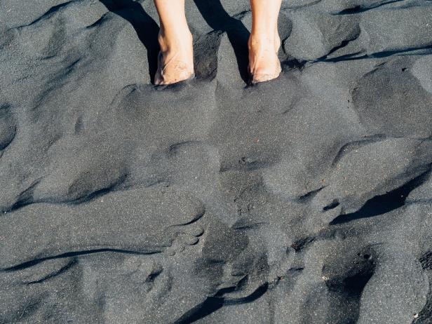 Feet in the black sand beach Feet in the black sand beach