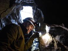 Host Scott Wolter examines inscriptions depicted on the walls of a mysterious cave found in Shippensburg, Pennsylvania. As seen on Travel Channel's America Unearthed.
