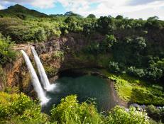 It's debatable as to which view of Wailua Falls is more beautifulfrom the above where you can appreciate its majesty or from below where the cool mist from the waterfall nourishes the hanging ferns and tropical foliage that create Kauai's popular Fern Grotto. You just might have to find out for yourself.
