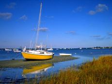 A sailboat rests on a strip of dry land at low tide on Nantucket Island off the coast of Massachusetts.
