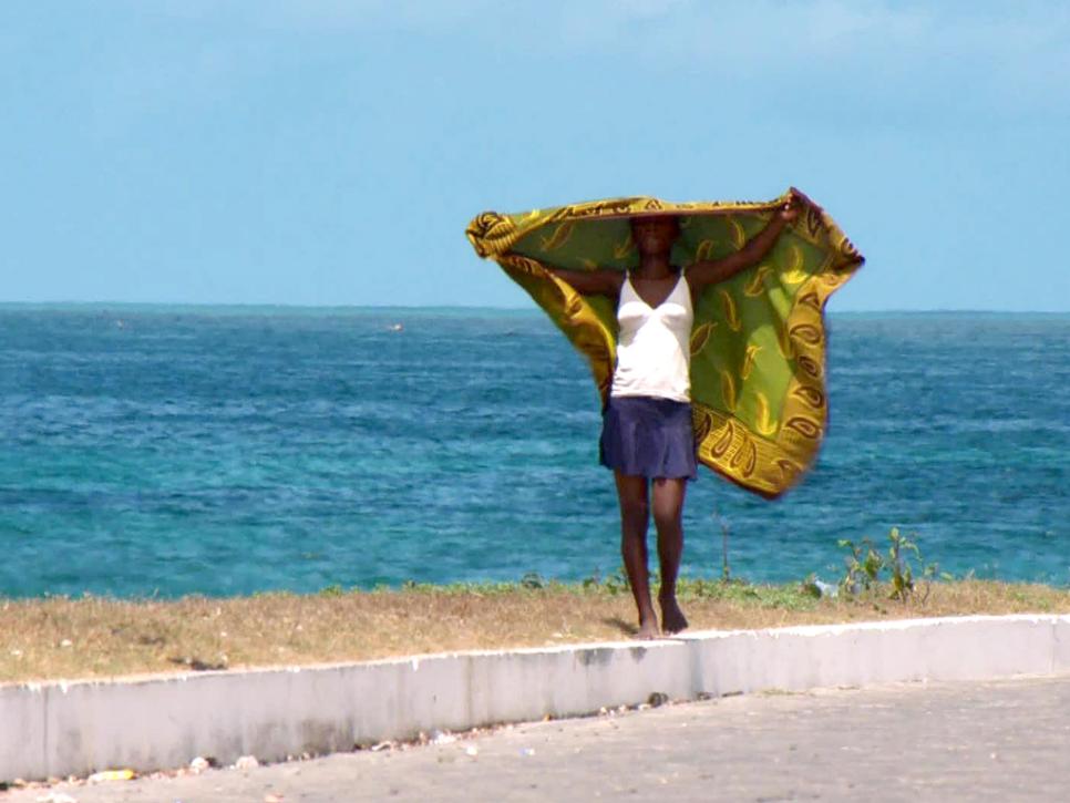 Woman walks along the ocean road