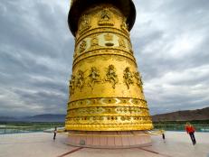 giant prayer wheel, tall golden statue, mother, 2 young boys,