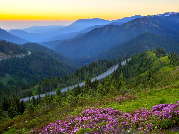 dusk view from the top of a mountain with a car on a road below, mountains in the background with golden sky behind it dusk view from the top of a mountain with a car on a road below, mountains in the background with golden sky behind it