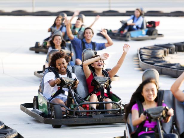 Young Women Ride Go Carts At An Amusement In The Daytime