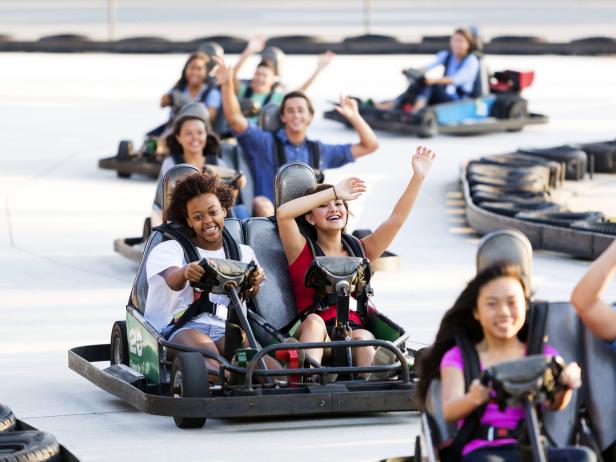 young women ride go carts at an amusement in the daytime young women ride go carts at an amusement in the daytime