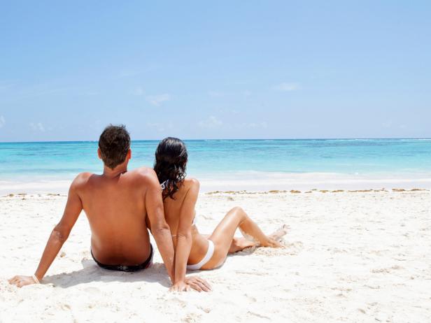 couple laying on the beach looking at the ocean couple laying on the beach looking at the ocean
