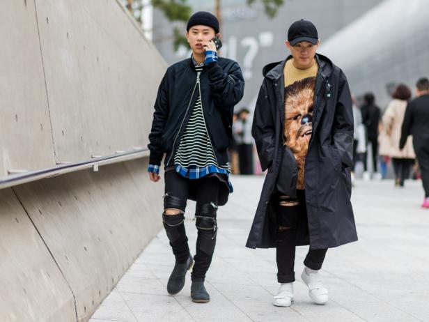 SEOUL, SOUTH KOREA - OCTOBER 22:  Guests wearing wool hat, cap, tshirt, ripped pants, bomber jacket and black Vetements rain coat on October 22, 2016 in Seoul, South Korea. (Photo by Christian Vierig/Getty Images)
