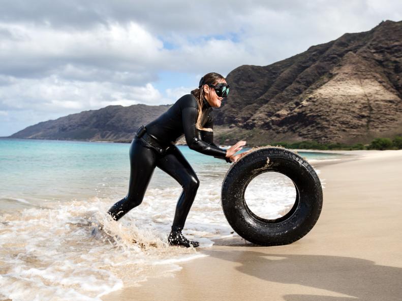 Asia Anderson pushing tire on Makua Beach in the Ka'ena Point State Park, Hawaii as seen on Travel Channel's Top Secret Beaches episode TTSB102H.