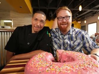 Chef Dre Lopez (left) and Host Josh Denny (right) sit down, ready to dig into the B.F.D., as seen on Ginormous Food, Season 2.