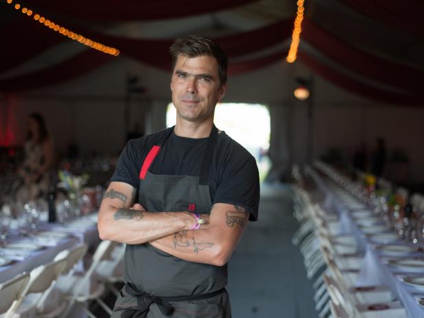 Celebrity chef Hugh Acheson poses in a Hedley & Bennett apron (designed in conjunction with Dominique Ansel) before presenting a three-course meal at the (RED) Supper at Bonnaroo, a charity dinner to fight AIDS. Acheson, a longtime advocate for (RED) and ONE, wrote the James Beard Award winning cookbook, A New Turn in the South, and created the (RED) Supper menu featuring pimento cheese sandwiches, pork loin with peaches and basil, buttermilk panna cotta with strawberries, and more.