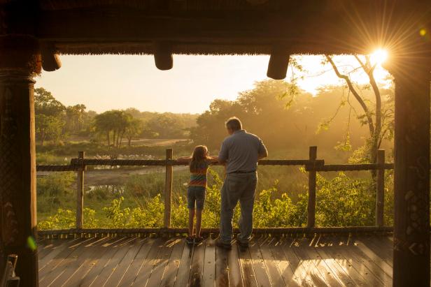 Man and Girl Standing on Platform Overlooking Savanna 