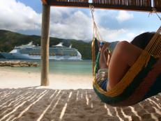  'A woman relaxes on a hammock on the beach in front of a large cruise ship
iStockphoto. Feb. 2008'