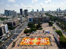 People arrange 500,000 flowers into a giant floral carpet at Rabin Square in Tel Aviv.