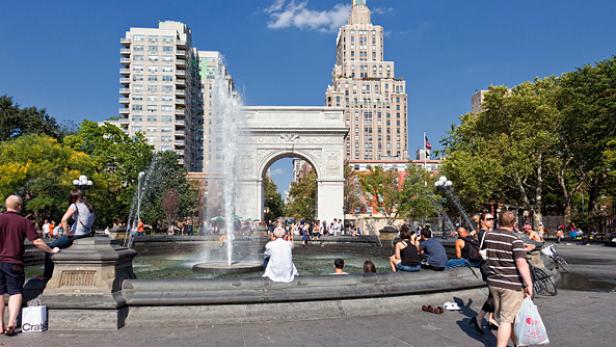 People keep cool on a warm fall day by enjoying the fountain in Washington Square Park in New York City. 