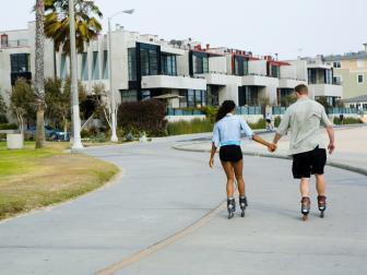 Couple skating together at beach, Venice, California