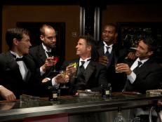 Men in dinner jackets drinking cocktails in bar