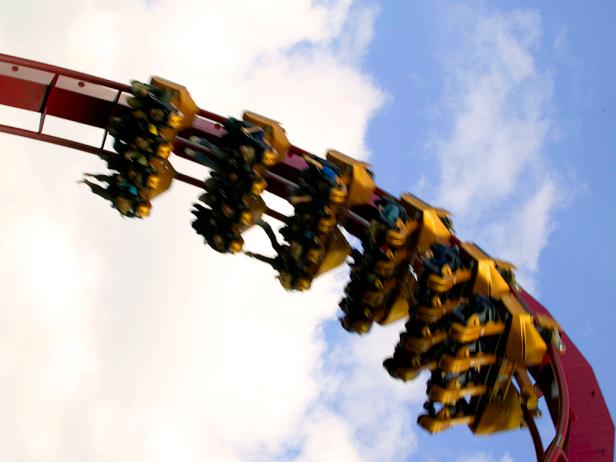  'People riding roller coaster, low angle view'