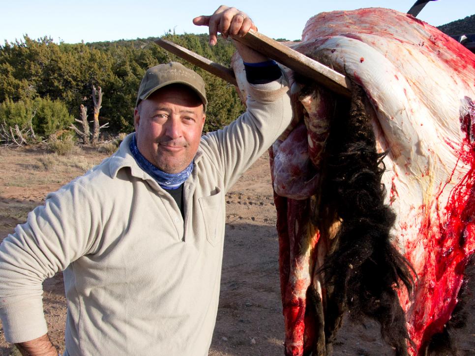 Andrew Zimmern stands next to a skinned hide of a buffalo in New Mexico