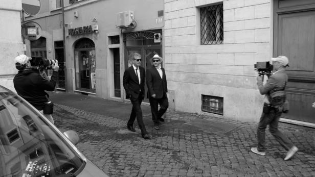 Anthony Bourdain walks down a street in Rome