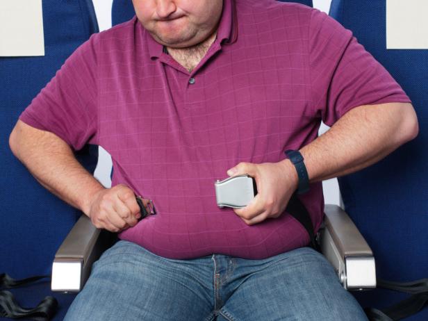 overweight airline passenger fastens seat belt