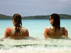 two topless women relaxing at the beach