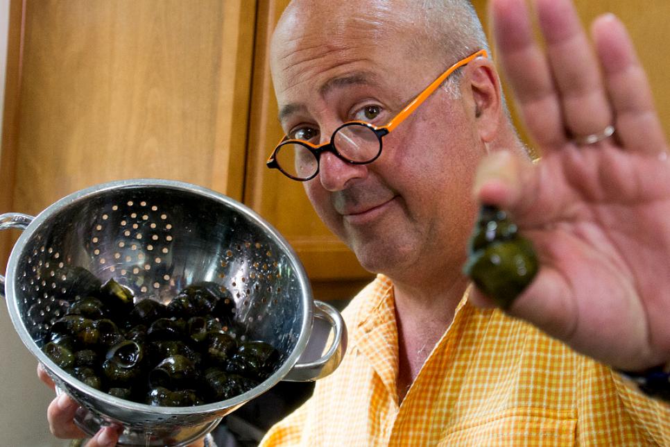 Andrew Zimmern holds a mystery snail