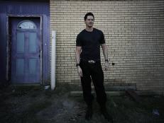  'Zak in front of a shadowy brick wall.'