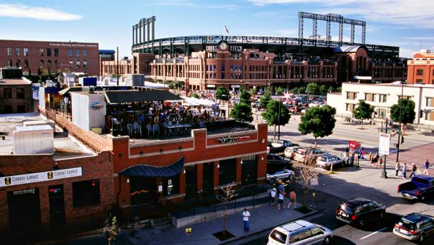 Traffic along Market Street with The Tavern Downtown and Coors Field in background.