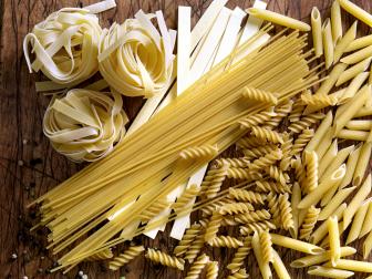 variety of dried pasta on wooden table