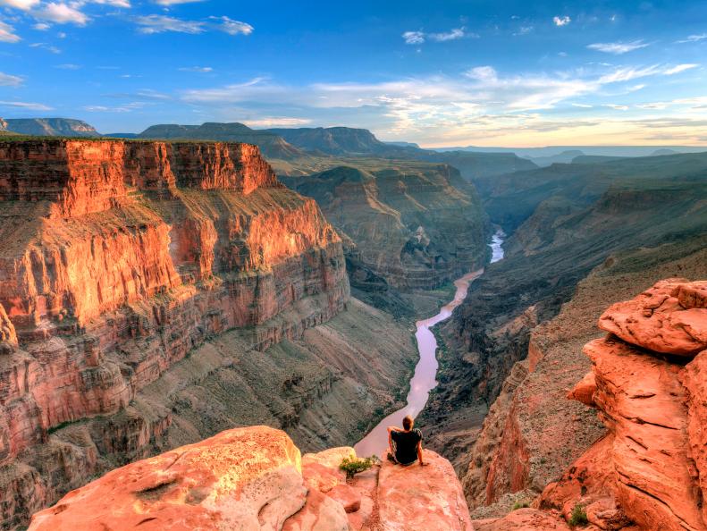 grand canyon sunset with man on cliff