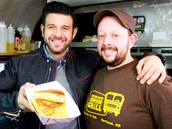 men posing, holding grilled cheese sandwich in container