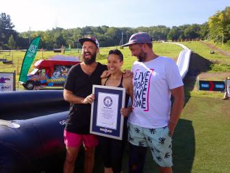 waterslide, daytime, people holding sign , greenery, world record