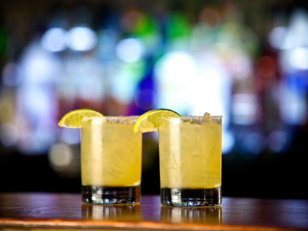 margaritas on bar with lemon wedges