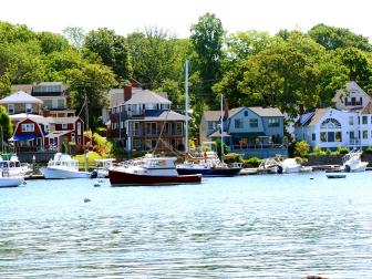 boats in harbor during the day with houses along the shore
