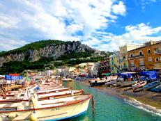 marina grande harbor with small boats on the island of capri with mountain in background during the day