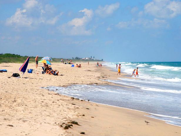 tourists and locals sunbath on beach at ocean during the day