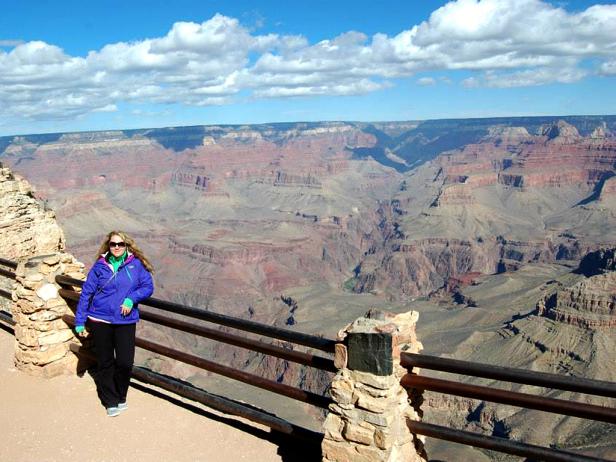 woman stands in front of grand canyon