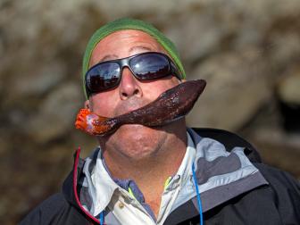 Andrew Zimmern eating sea cucumber in Alaska