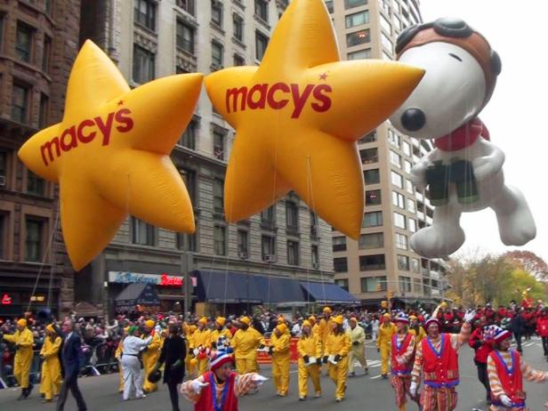 Snoopy and Macy's balloons floating above the crowd at the Macy's Thanksgiving Parade in New York