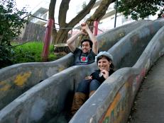 Couple sliding down slides at Seward Mini Park in San Francisco