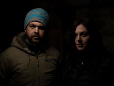 Hosts Jack Osbourne and Katrina Weidman posing for a photo in front of a black background. As seen on Travel Channel's Portals To Hell.