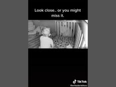 As the toddler sits up, a minute light rises with him, floating straight up before disappearing. The video caption states, “We have paranormal things happen a lot in our home…”