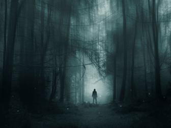 A spooky hooded figure, standing in a winter forest. With glowing supernatural lights. With a blurred, grunge, edit