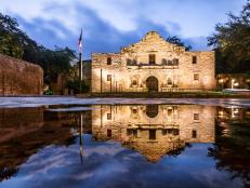 The Alamo Chapel in San Antonio reflects over a lake