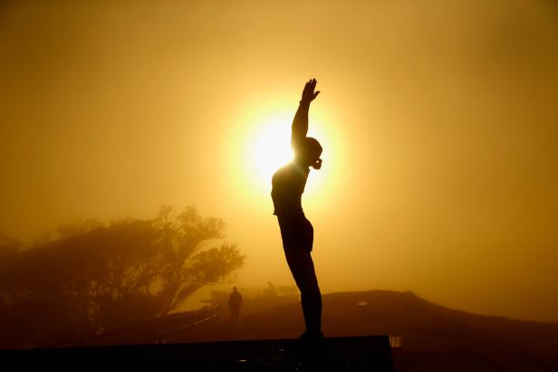 A lady practices yoga on the summit of Mt Eden as the sun struggles to shine through a blanket of fog over Auckland City on May 4, 2016 in Auckland, New Zealand. The morning fog disrupted flights and ferry services in the city.  