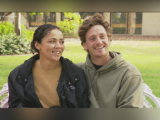 Lateche Norris (left) and her boyfriend, Joseph “Joey” Smith (right). Sitting in front of a green grass background, Lateche looks at her Joey smiling wearing a black jacket and a tan top. Joey smiles wearing a green sweatshirt.