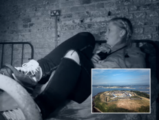 Chelsea Laden is on a bed in a haunted room at Spike Island. She is wearing ripped jeans and sneakers. She has a shocked look on her face. Inset is an aerial view of the island.